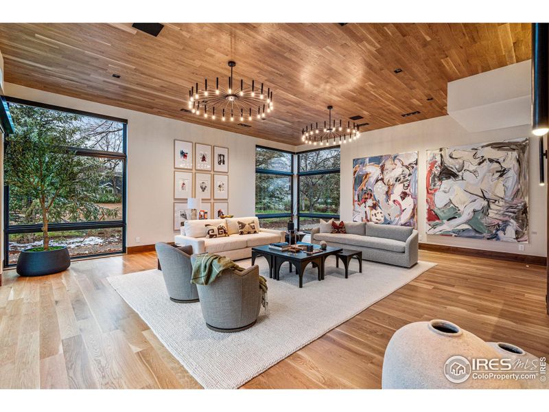 Living Room with beautiful wide plank white oak floors, white oak ceilings, Jerusalem limestone accents walls, Lutron ceilings and floor up-lighting as well as Lutron mechanical shades.