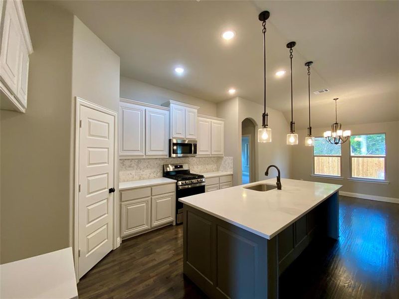 Kitchen features cabinet wrapped island in Gaunlet Grey & Calacatta Lincoln quartz which seems like a custom furniture piece Kitchen features cabinet wrapped island in Gaunlet Grey & Calacatta Lincoln quartz which seems like a custom furniture piece