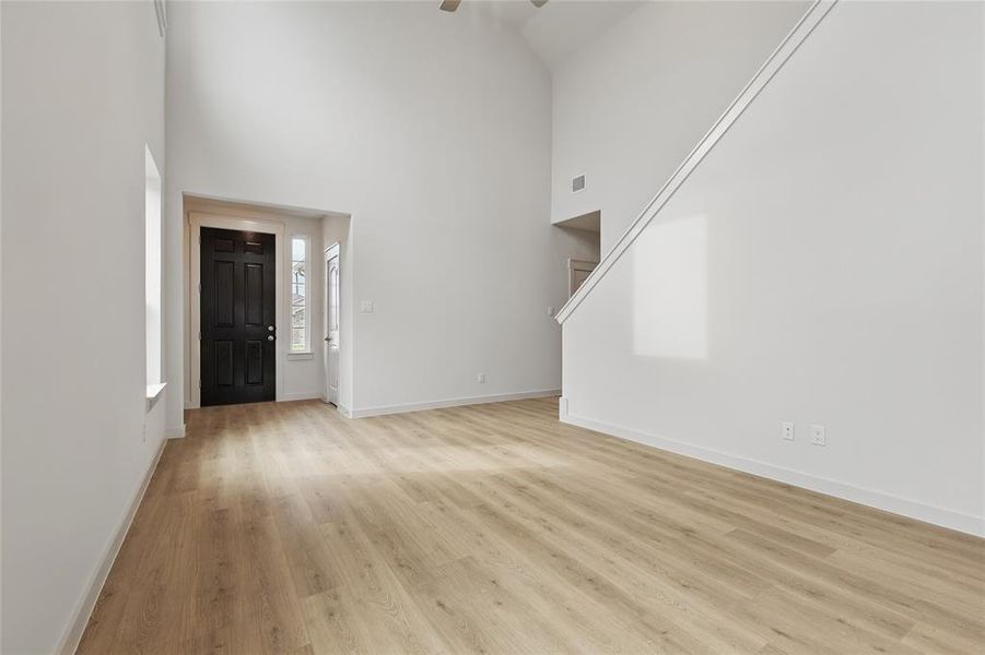 Foyer entrance featuring a high ceiling, light wood-style flooring, and a ceiling fan