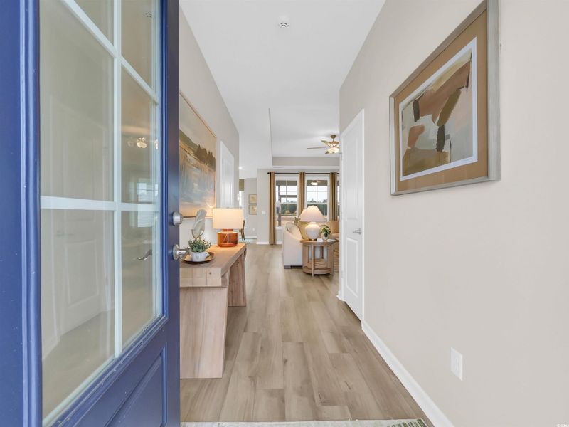 Hallway with light wood-style floors and baseboards