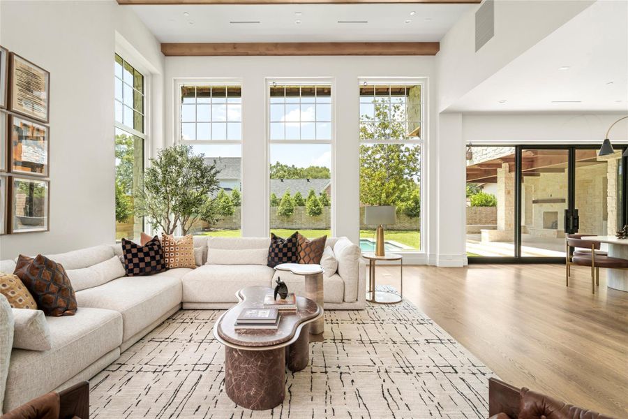 Designed for effortless indoor-outdoor living, the great room flows seamlessly into the kitchen and breakfast area, framed by soaring windows and steel doors overlooking the pool and backyard. Alder ceiling beams and wide-plank white oak floors bring warmth to the light-filled space. Enhanced photo. Existing overhead power lines are scheduled to be relocated underground. Designed for effortless indoor-outdoor living, the great room flows seamlessly into the kitchen and breakfast area, framed by soaring windows and steel doors overlooking the pool and backyard. Alder ceiling beams and wide-plank white oak floors bring warmth to the light-filled space. Enhanced photo. Existing overhead power lines are scheduled to be relocated underground.