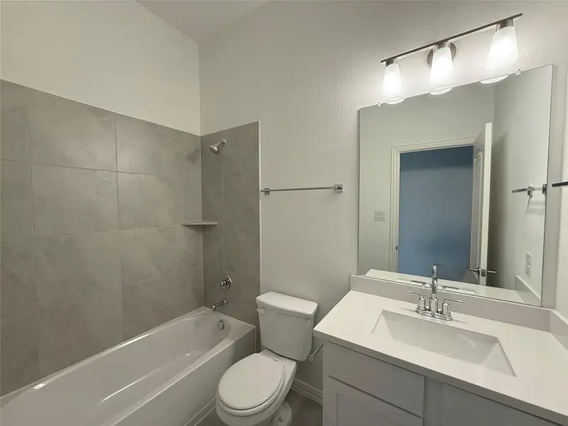 Full bathroom with shower / bathtub combination, vanity, and a textured wall Full bathroom with shower / bathtub combination, vanity, and a textured wall