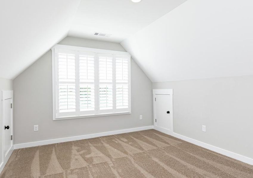 Secondary bedroom with carpet and a very large window.