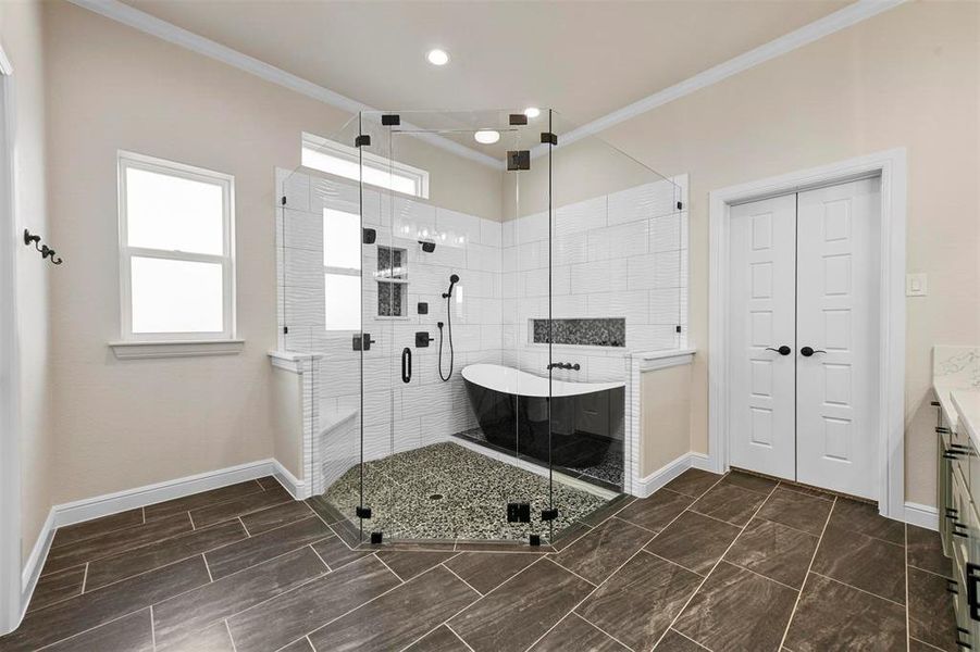 Bathroom with crown molding, vanity, and independent shower and bath