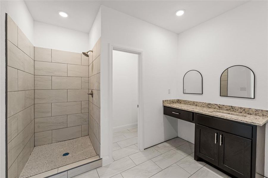 Bathroom featuring vanity and tiled shower