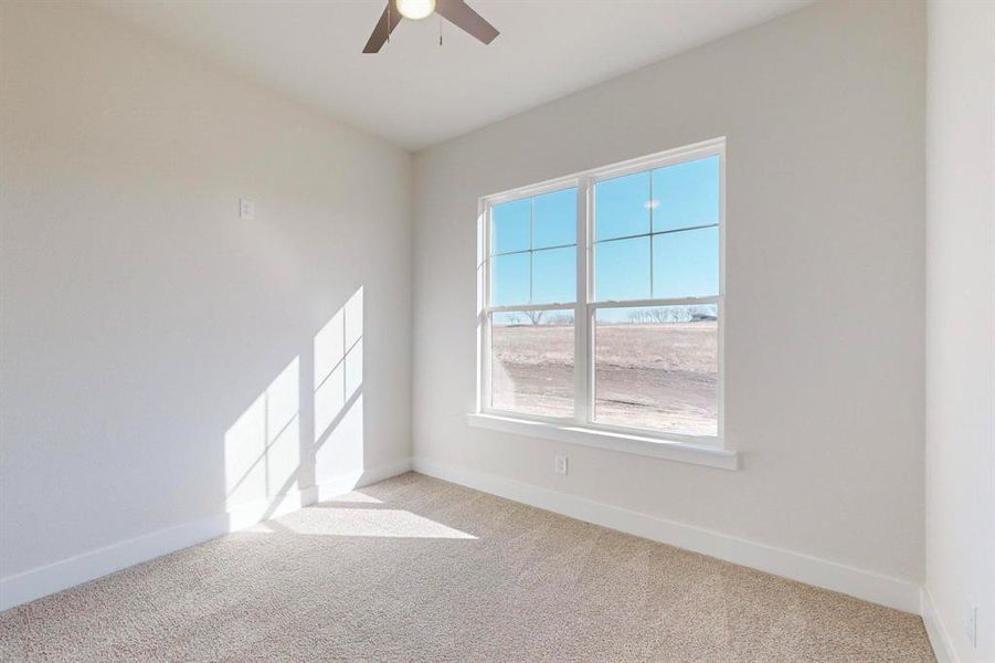 Carpeted empty room with ceiling fan