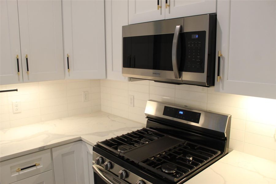 Culinary delights await in this bright kitchen with contemporary cabinetry and sleek countertops.
