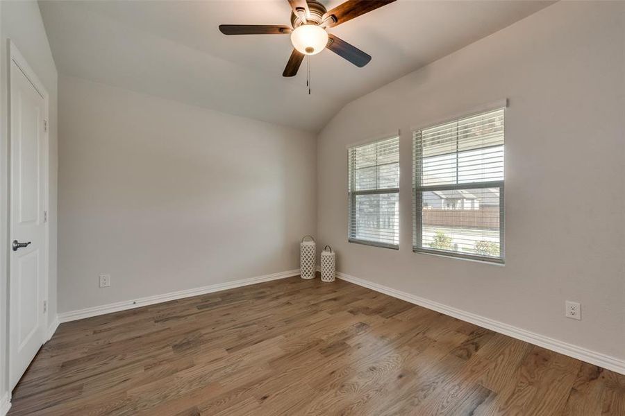 Front bedroom featuring lofted ceiling, ceiling fan and hardwood flooring