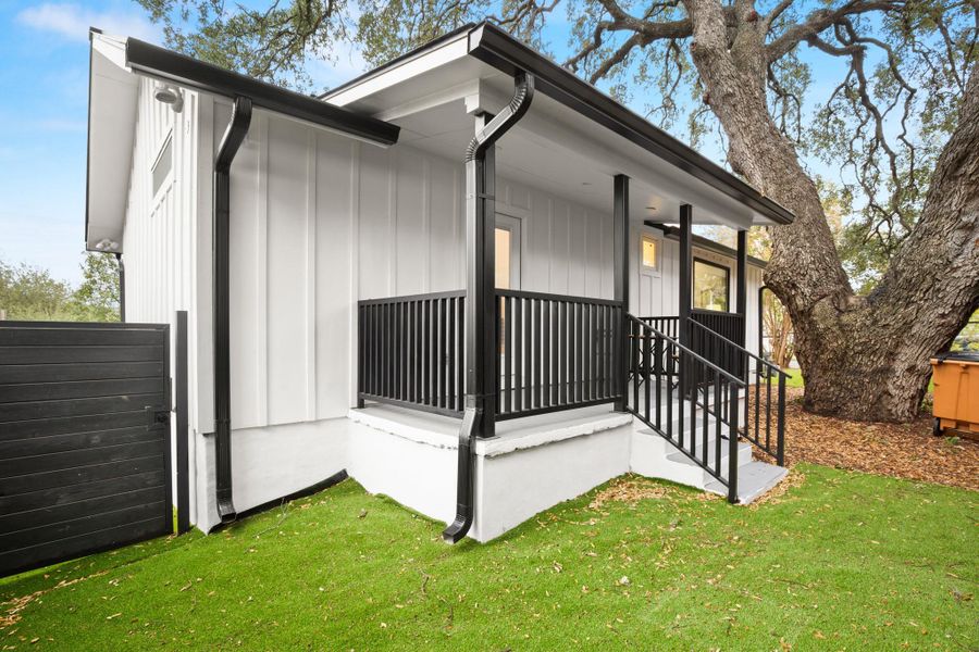 View of front of property featuring board and batten siding, a porch, and a front lawn