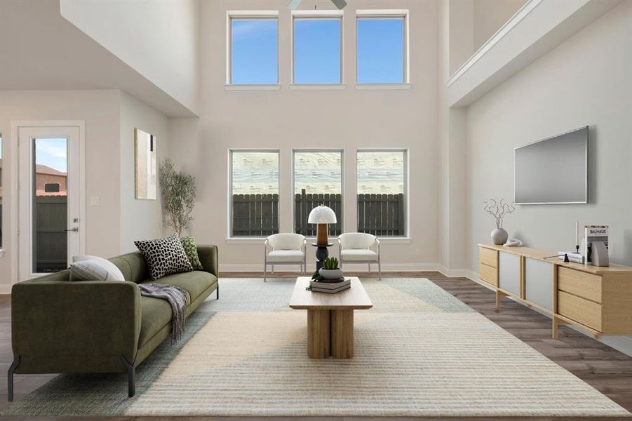 Living area featuring dark wood-style flooring, healthy amount of natural light, a high ceiling, and ceiling fan