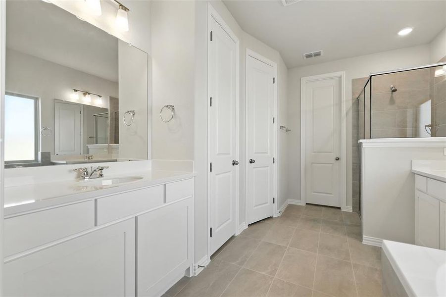 Full bath with a shower stall, vanity, light tile patterned flooring, a closet, and a bathtub Full bath with a shower stall, vanity, light tile patterned flooring, a closet, and a bathtub