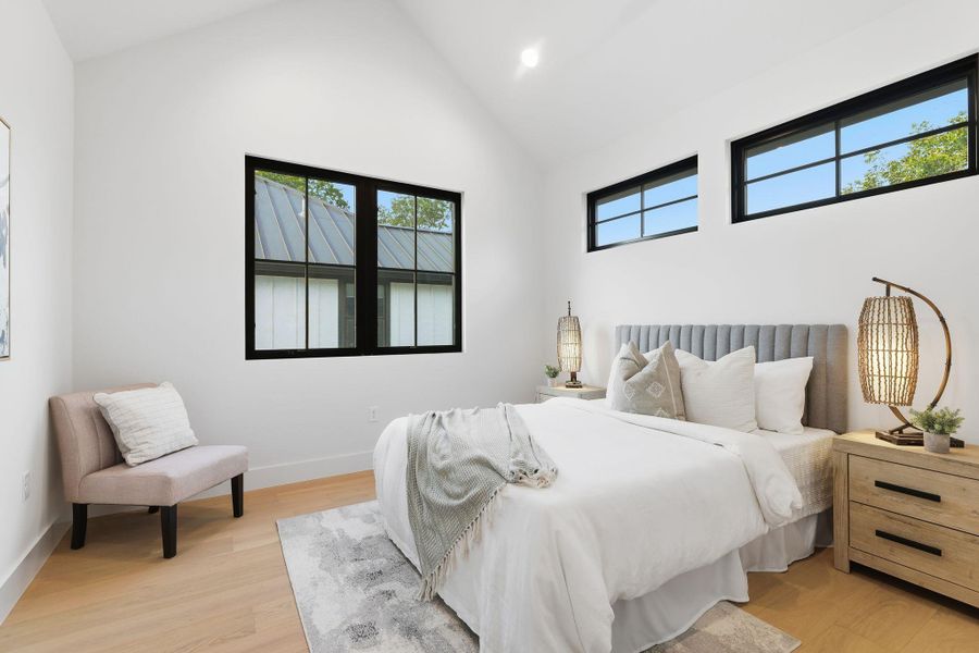 Bedroom featuring vaulted ceiling, light wood-style flooring, and recessed lighting