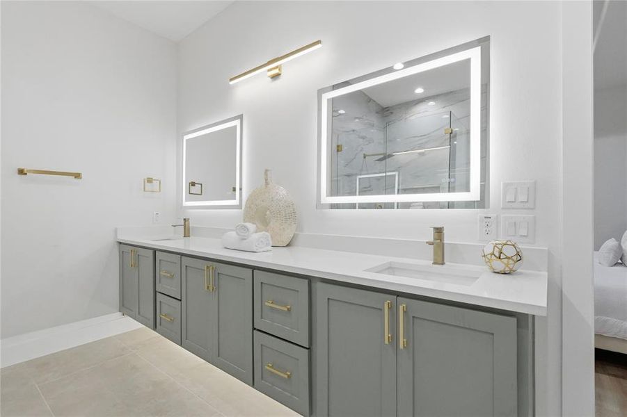 Full bathroom with double vanity, a marble finish shower, and tile patterned floors