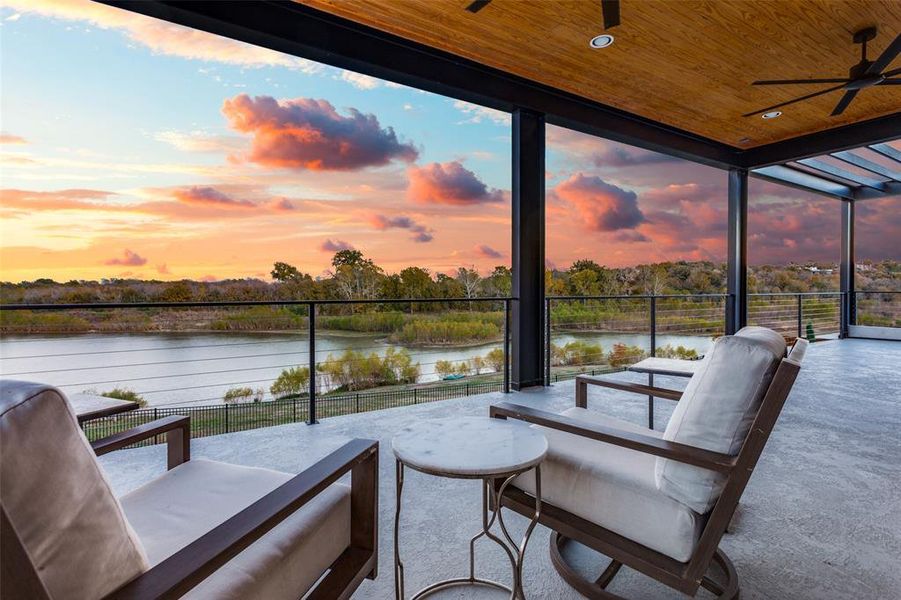 Patio terrace at dusk with ceiling fan and a water view