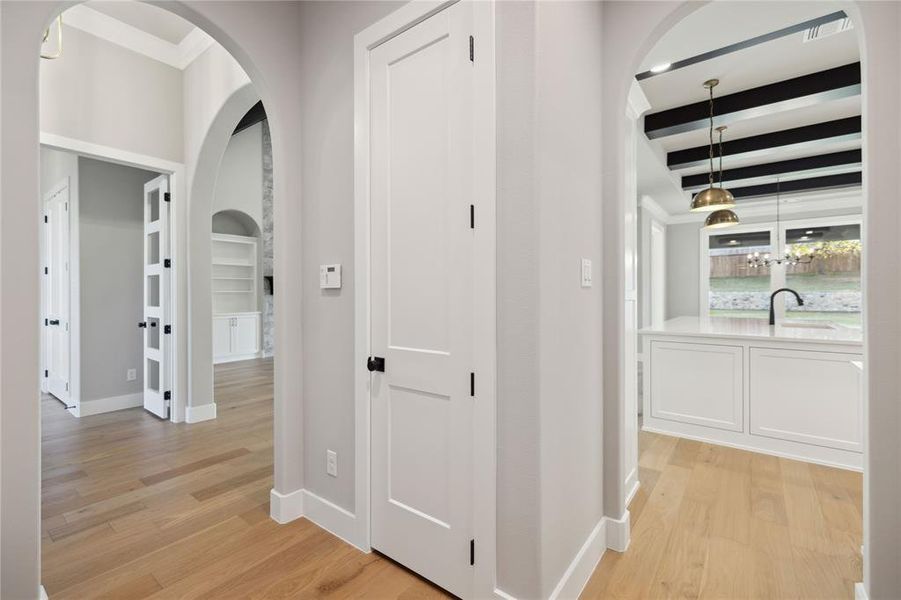 Corridor with beam ceiling, sink, and light wood-type flooring