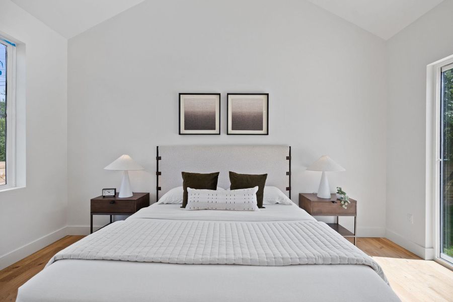 Bedroom featuring lofted ceiling, light wood-type flooring, and access to exterior Bedroom featuring lofted ceiling, light wood-type flooring, and access to exterior