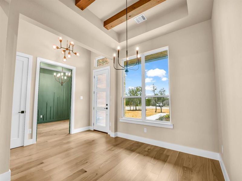 Unfurnished dining area with light hardwood / wood-style flooring, plenty of natural light, and an inviting chandelier