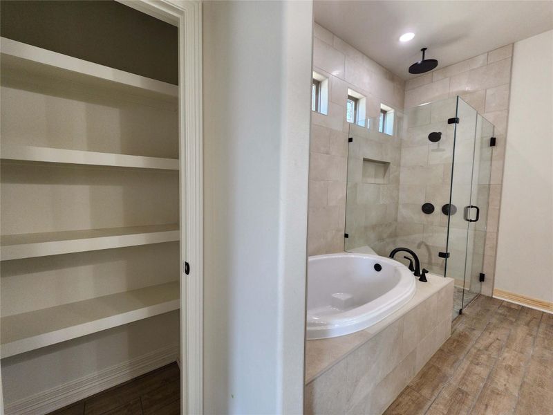 Bathroom featuring wood finished floors, a stall shower, and a bath