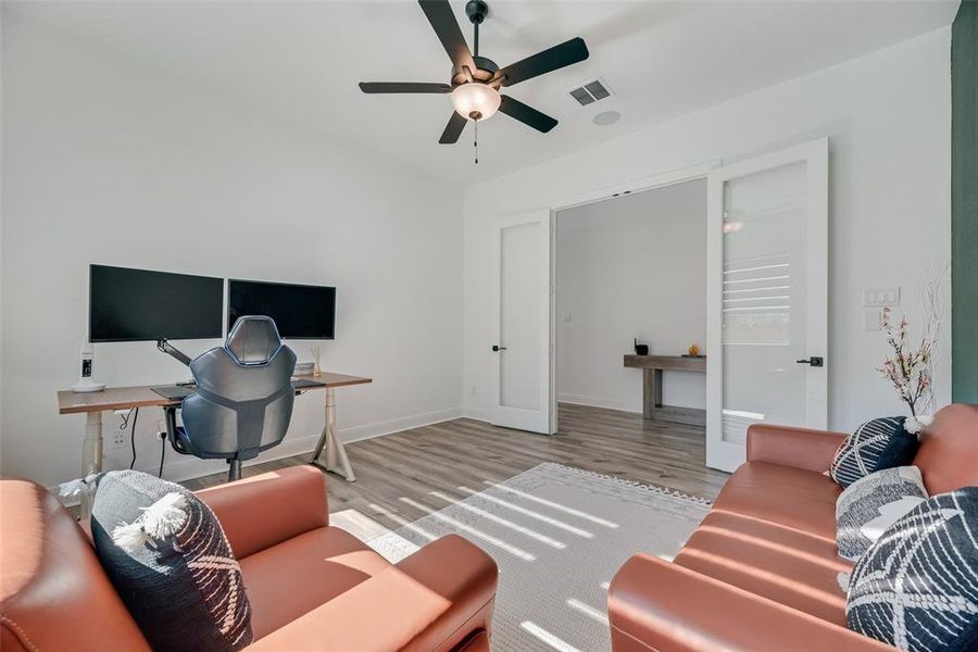 Office area featuring wood finished floors, ceiling fan, and french doors