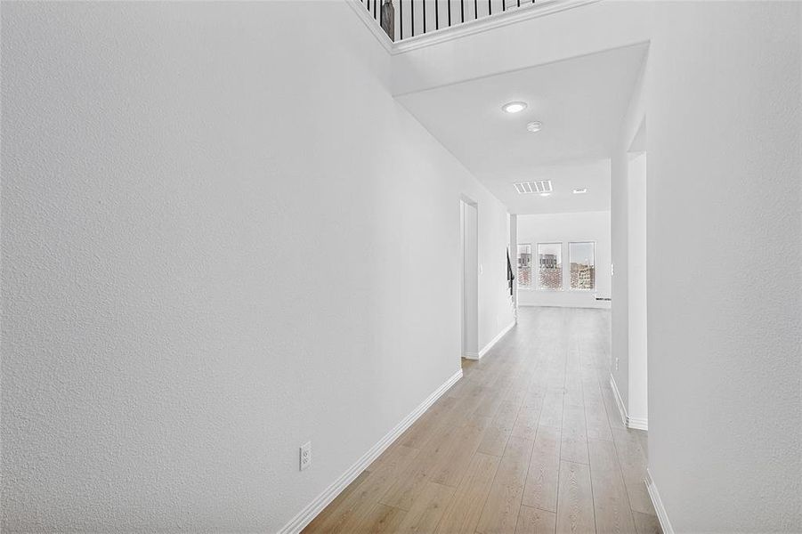Hallway featuring light wood finished floors and recessed lighting Hallway featuring light wood finished floors and recessed lighting