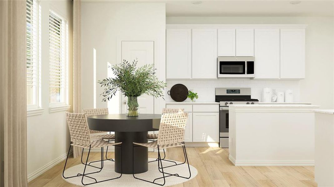 Kitchen featuring stainless steel range, light hardwood / wood-style floors, a healthy amount of sunlight, and white cabinetry