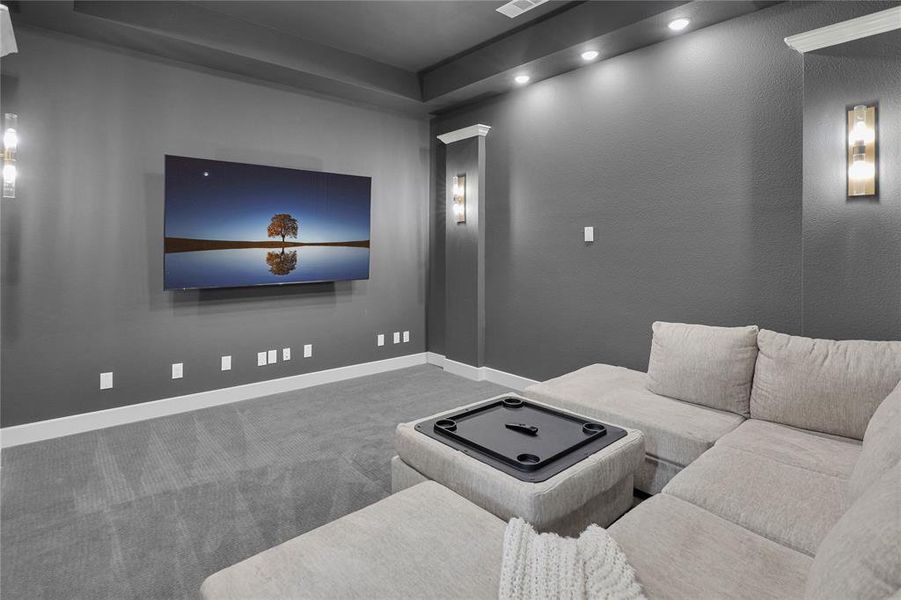 Entertainment room featuring dark gray walls, recessed ceiling lighting, and wall-mounted sconces
