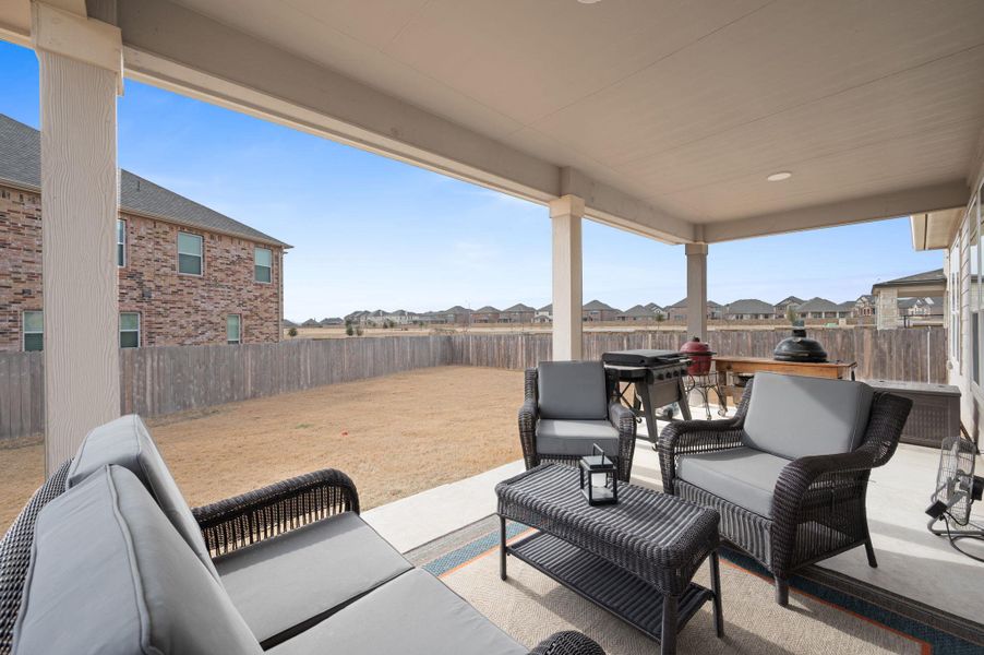 Fenced backyard featuring a patio area, outdoor furniture, and a residential view