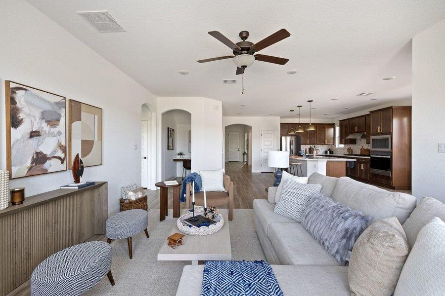 Living area with arched walkways, ceiling fan, wood finished floors, and recessed lighting Living area with arched walkways, ceiling fan, wood finished floors, and recessed lighting