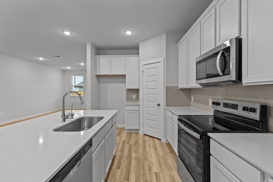 A kitchen with white cabinets.
