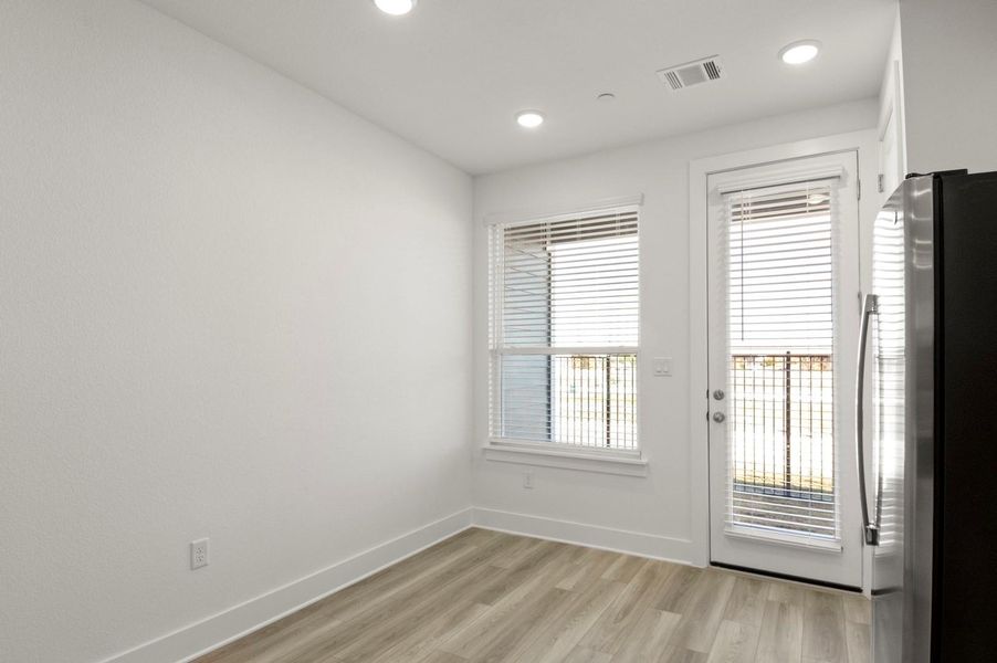 Empty room with light wood-type flooring and recessed lighting