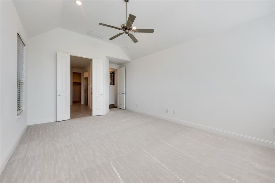 Unfurnished bedroom with lofted ceiling, light tile patterned floors, and ceiling fan