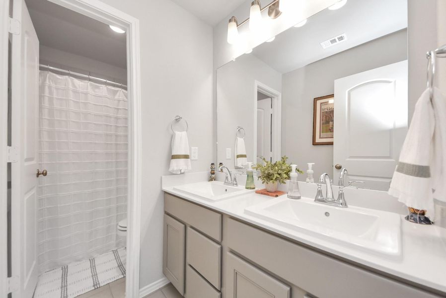 Full bath with dual sinks that is located across from bedrooms #2 and #3 upstairs. Separate dual sink area with tub/shower combination located in the distance along with the toilet space. Pretty fixtures and so light and bright. Full bath with dual sinks that is located across from bedrooms #2 and #3 upstairs. Separate dual sink area with tub/shower combination located in the distance along with the toilet space. Pretty fixtures and so light and bright.