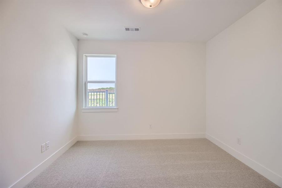 Empty room featuring light colored carpet and baseboards Empty room featuring light colored carpet and baseboards