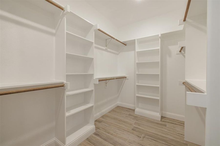 Walk in closet with light wood-type flooring