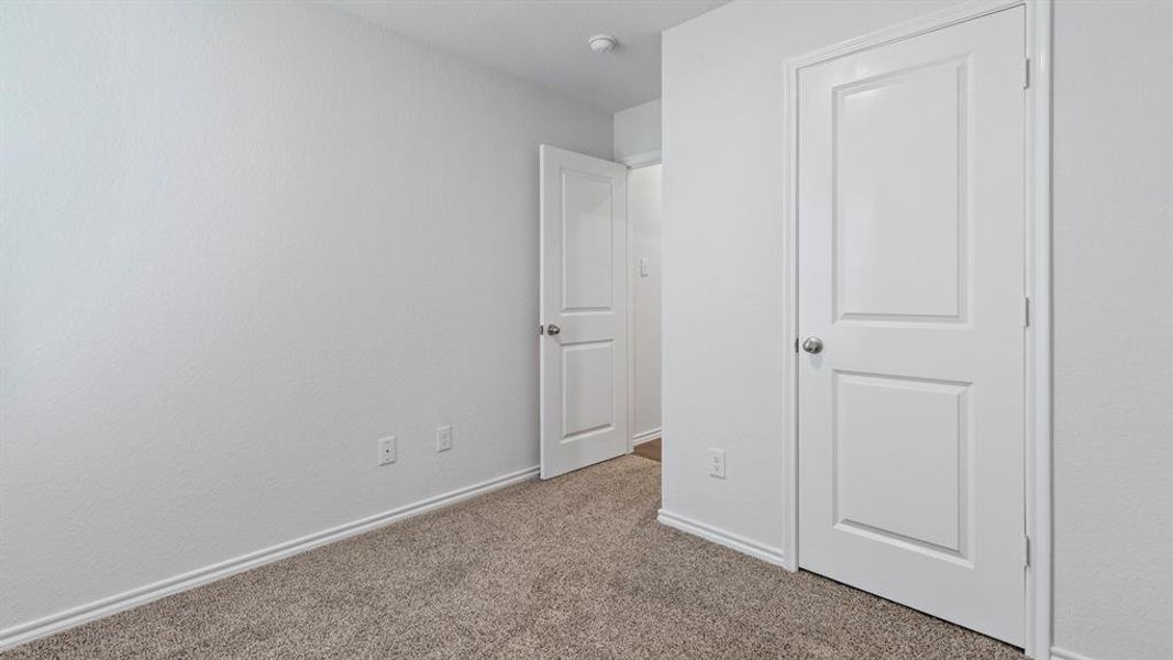 Unfurnished bedroom with carpet flooring and baseboards