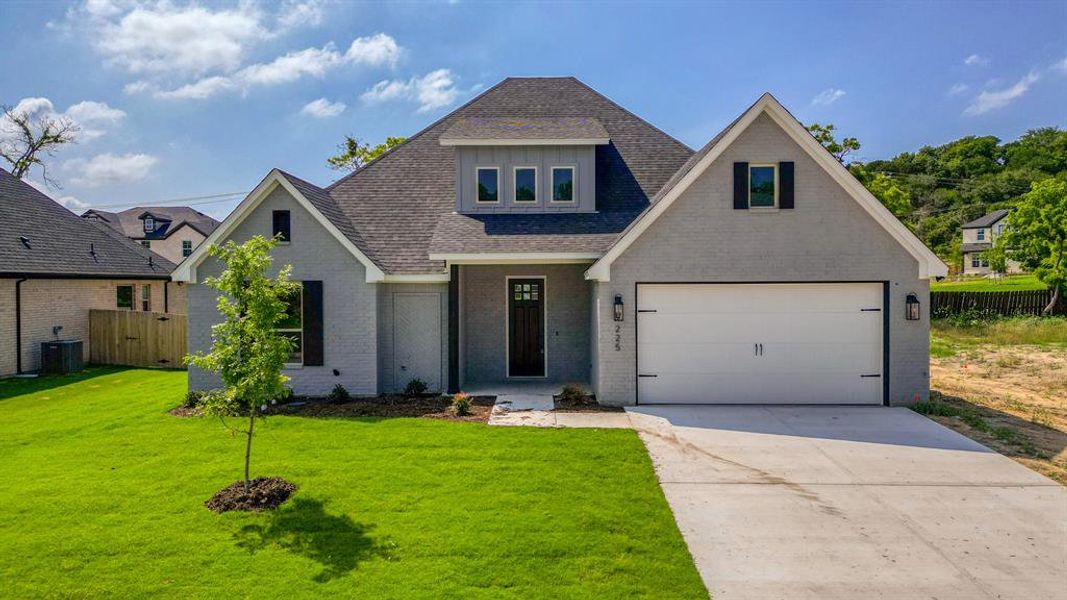 View of front of property with a garage, central AC, and a front lawn