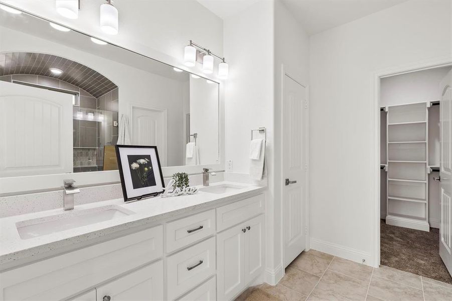 Bathroom with vanity, tiled shower, and tile patterned flooring