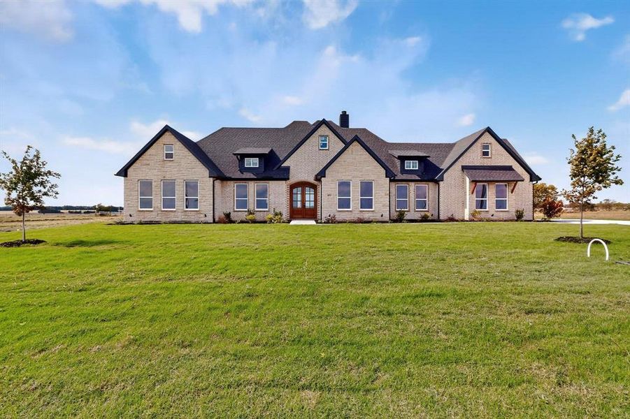 View of front of property with a front lawn, a chimney, and stone siding View of front of property with a front lawn, a chimney, and stone siding