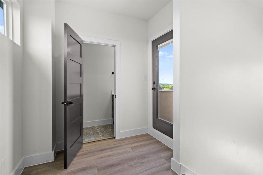 The property features light-colored flooring, a modern panel door, a transom window, and a glass-paneled exterior door The property features light-colored flooring, a modern panel door, a transom window, and a glass-paneled exterior door