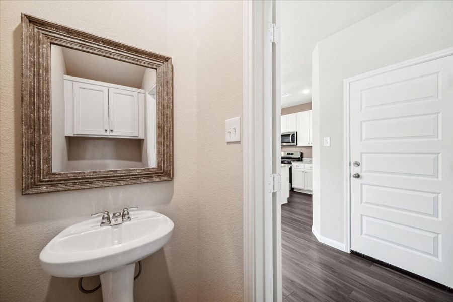 Decorative mirror and cabinet added to powder room