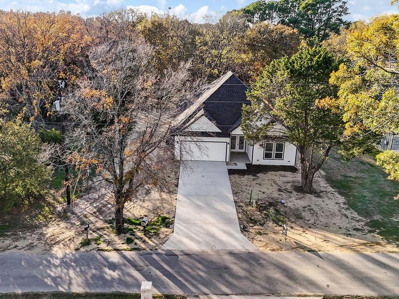 View of front of house with concrete driveway and roof mounted solar panels
