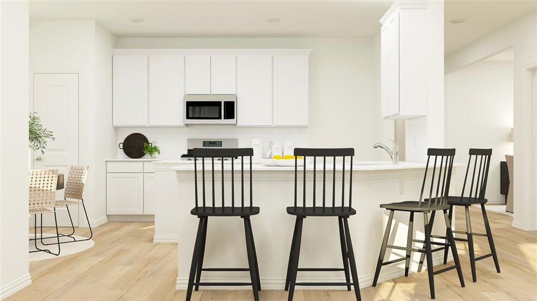 Kitchen with a breakfast bar, tasteful backsplash, light hardwood / wood-style flooring, and white cabinets