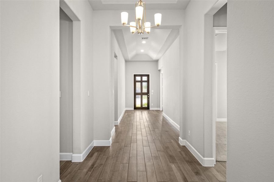 Grand entry hall showcasing the 12-foot Coffered Ceiling and luxurious Wood-Look Tile Flooring.