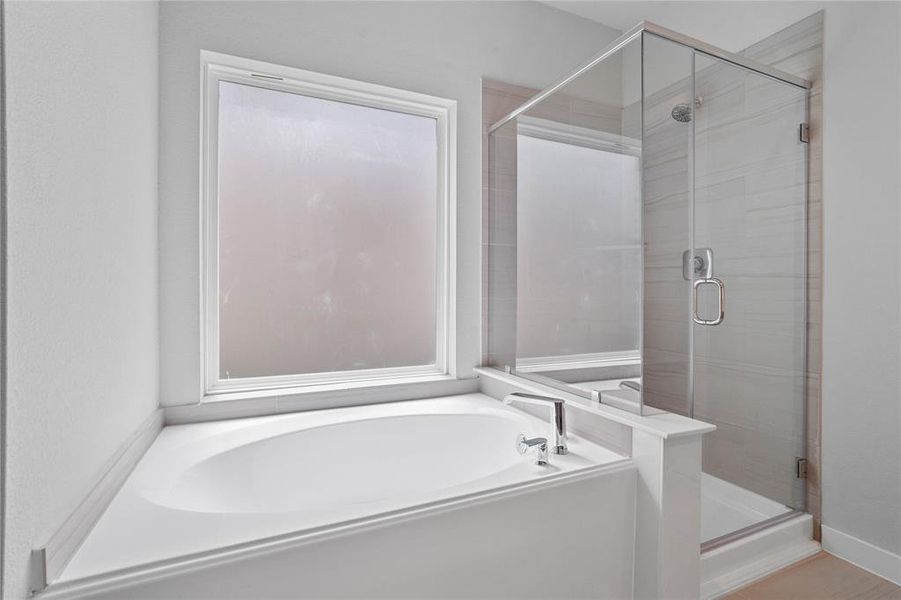 This primary bathroom is definitely move-in ready! Featuring a framed walk-in shower with tile surround, separate garden tub for soaking after a long day!