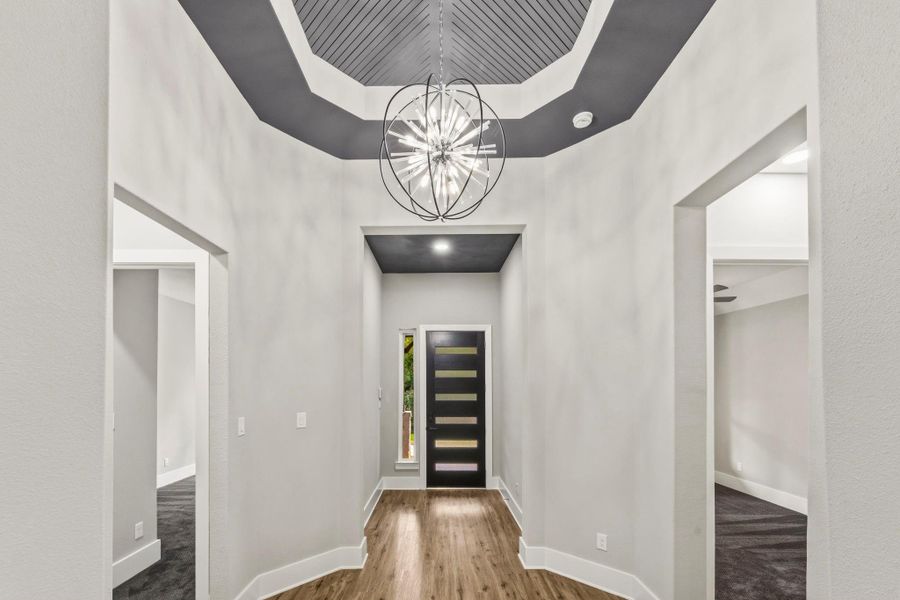 A dramatic foyer sets an elevated tone with soaring ceilings, architectural detailing, and statement lighting.