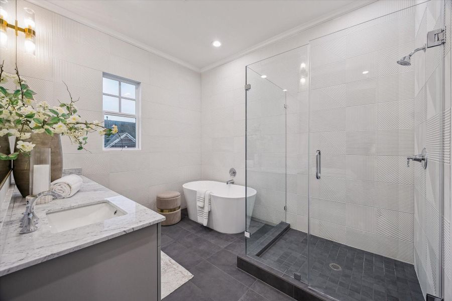 Freestanding soaking tub and frameless glass shower.
