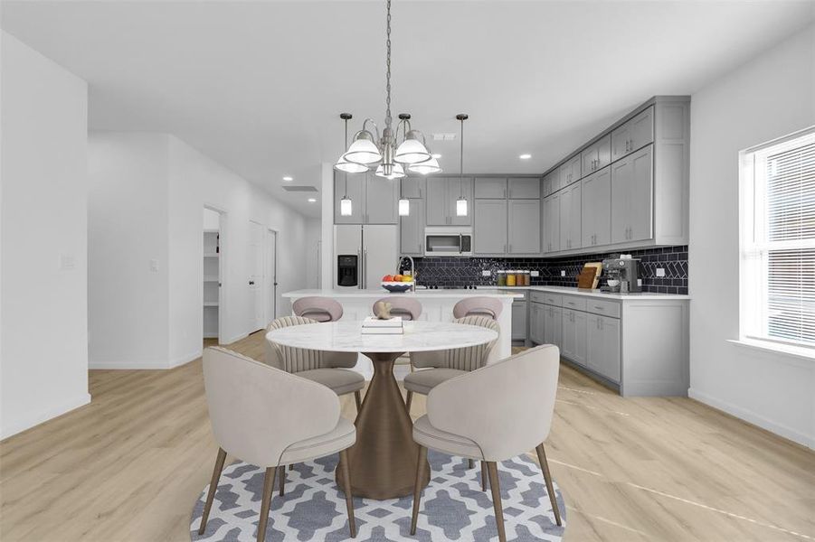 Dining room with light wood finished floors and a chandelier