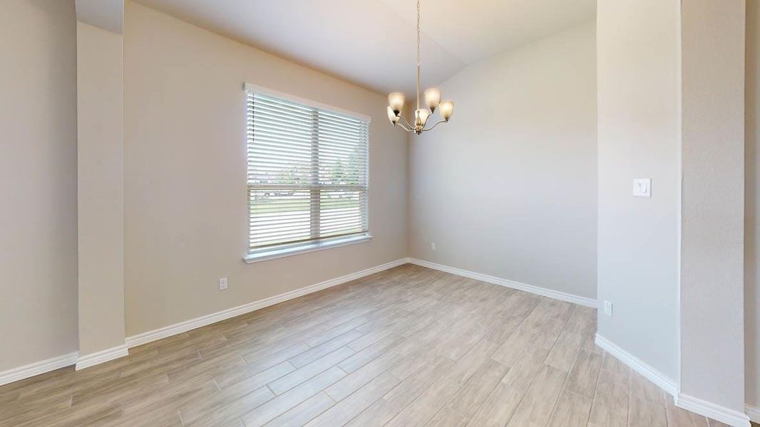 Empty room with lofted ceiling, light wood-type flooring, and suspended lighting