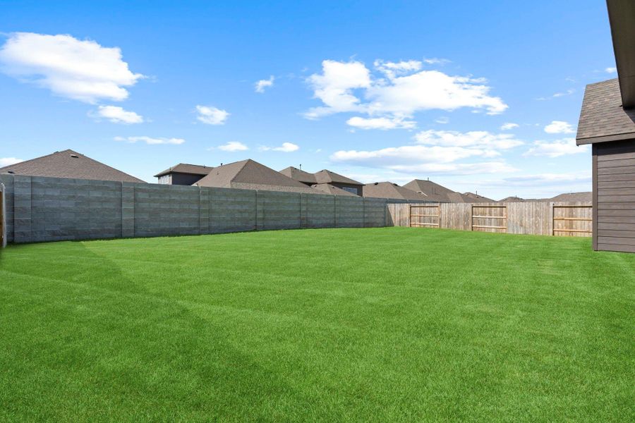 Large, private backyard with a lush green lawn and plenty of space for play, gardening, or future outdoor projects.