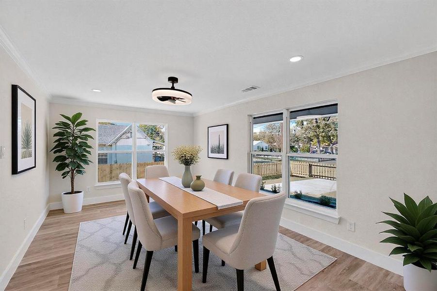 Dining space with light wood-style flooring, crown molding, plenty of natural light, and recessed lighting